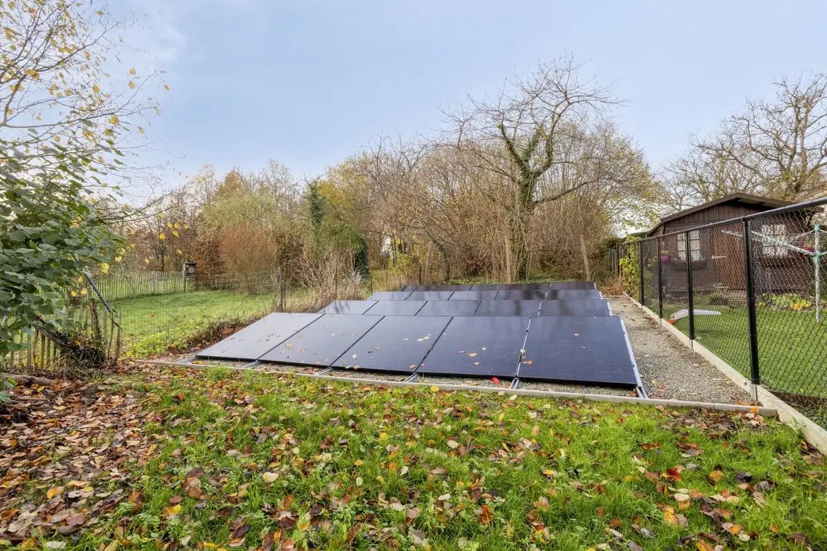Grondopstelling met zonnepanelen achteraan in de tuin